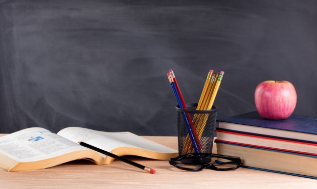 Desktop in classroom ready to learn from textbooks