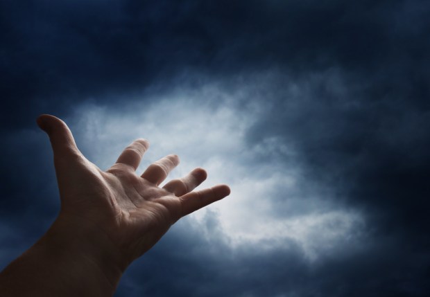 Hand reaching for the cloud in the sky