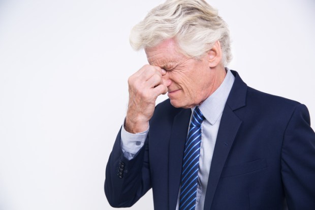 Stressed senior Caucasian businessman rubbing eyes