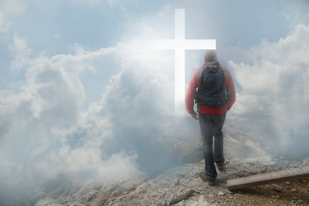 Man looking a Christian cross